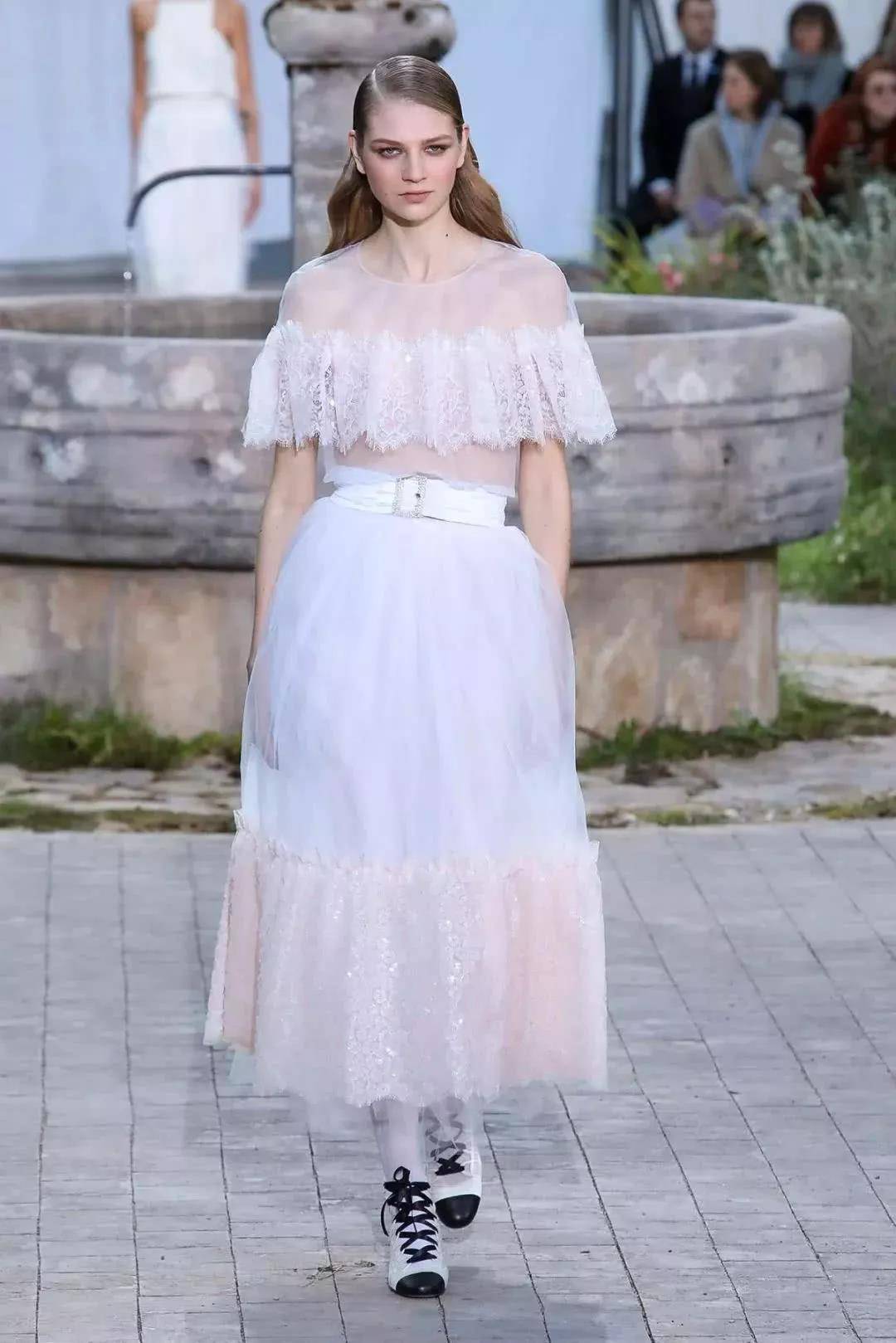 宽大的象牙色塔夫绸斗篷,下面搭配海军蓝色塔夫绸连衣裙;多层连衣裙以